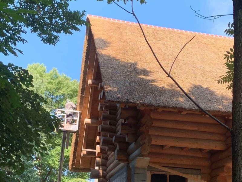 finition d'une toiture en chaume sur un chalet en bois - Art et Elégance Couverture
